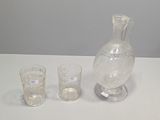 trois verres et un pichet posés sur une table