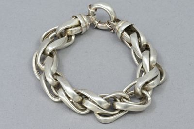 un gros plan d'un bracelet à chaîne en argent posé sur une table