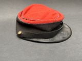 un chapeau rouge posé sur un chapeau noir, posé sur une table