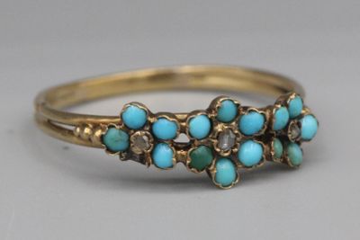 Gros plan sur une bague en or ornée de turquoises