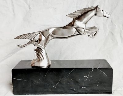 statue d'un cheval posée sur un socle en marbre, sur fond blanc