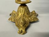 a gold candle holder with a bird on top of it