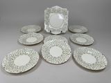 six assiettes blanches et vertes et un cadre photo posés sur une table
