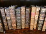 de nombreux livres anciens alignés sur une étagère en bois