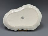 a close up of a white plate with a gold handle
