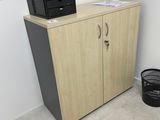 a cabinet with a printer on top of it next to a trash can