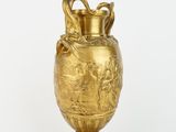a gold vase that is sitting on a stand