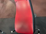 a red seat on a gym machine in a gym