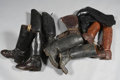 Plusieurs paires de bottes sont alignées sur une surface blanche