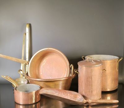 a lot of copper pots and pans on a table