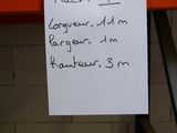 a piece of paper on a shelf with a note attached to it