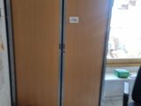 a room with a door and a trash can in it