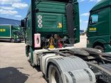 two green trucks parked next to each other in a parking lot