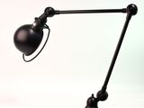 une image représentant une lampe de bureau noire sur fond blanc
