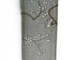a small plate with a flower on it on a white surface