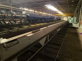 a long conveyor belt in a factory with cows in it
