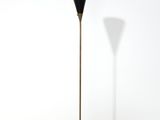 un lampadaire noir posé sur un sol blanc