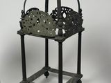 a small metal basket with a crown on it