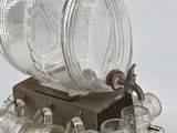an old fashioned glass beverage dispenser on a wooden stand