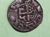 an old coin with a cross on it sitting on a green surface