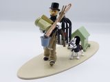 a figurine of a man with skis and a dog on a surfboard