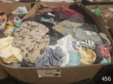 a cardboard box filled with clothes and other items