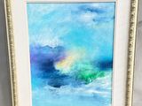 un tableau représentant des vagues bleues et vertes, dans un cadre blanc