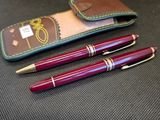 deux stylos et un étui posé sur une table, dans lequel se trouve un stylo