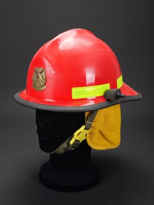 un casque de pompier rouge surmonté d'un chapeau jaune