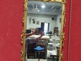 un miroir accroché au mur rouge d'une pièce