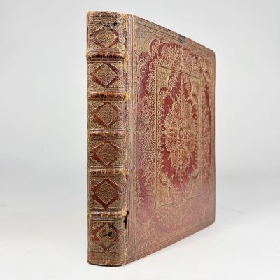 un vieux livre orné de motifs dorés et rouges