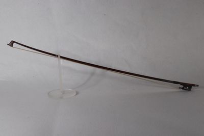 une image représentant un arc posé sur un support, sur une surface blanche