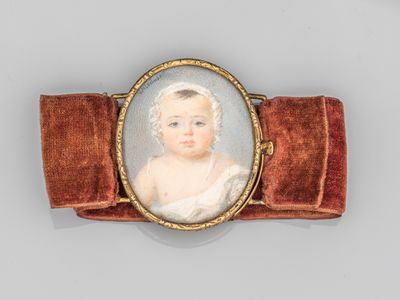 une image représentant un petit portrait d'un bébé portant un nœud en velours rouge