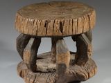 an old wooden stool with a wooden seat on it