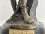 bronze statue of a man with a dog on a rock with a plaque on it