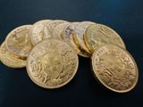 a pile of gold coins sitting on top of a black surface