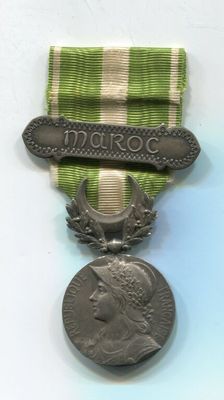 Une vieille médaille est posée sur une table, entourée d'un ruban.