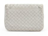 the white clutch bag has a woven design on the front of it