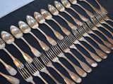 a lot of silver spoons and forks on a table