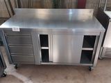 a stainless steel work table with drawers and a refrigerator