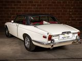 a white car that is parked in front of a brick wall
