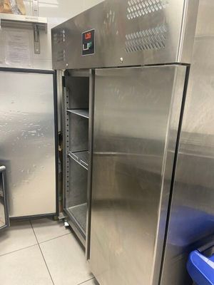 des réfrigérateurs en acier inoxydable dans une cuisine professionnelle, avec une poubelle bleue