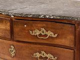 a marble top chest of drawers with brass handles