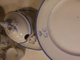a plate with a blue border and a cup and saucer with a saucer and a plate with a saucer and a saucer on it