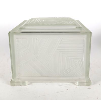 une boîte en verre avec un couvercle, posée sur une surface blanche