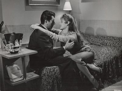 une photo en noir et blanc d'un homme et d'une femme assis sur un lit