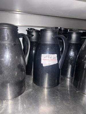 a lot of black jugs sitting on a table