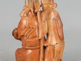 two figurines of a man and a woman sitting on a rock