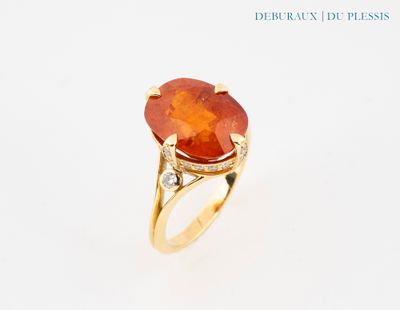 une image représentant une bague ornée d'une pierre orange entourée de diamants