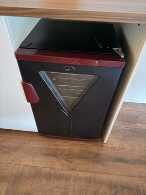 un petit poêle noir et rouge dans un coin de la pièce